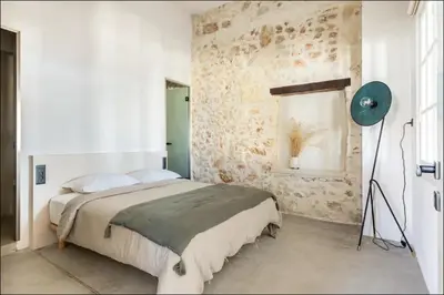 a bedroom with a bed and a stone wall at PETRA - casa casa group in Chania Town