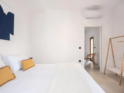 a white bed in a white room with a chair at ALS - casa casa group in Chania Town