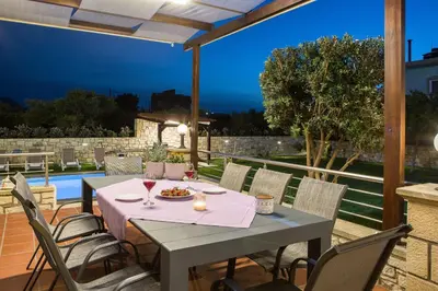 a table and chairs on a patio with a view at Villa Archontissa in Análipsis