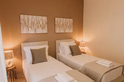 two beds in a small room with two lamps at Blue Port in Chania in Souda