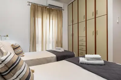 a bedroom with two beds and a closet at Blue Port in Chania in Souda