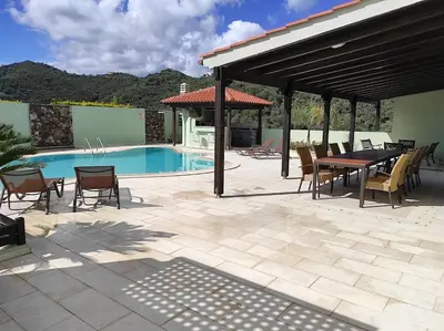 a patio with a table and chairs next to a pool at Villa Chloe - Amazing view Villa with swimming pool in Chania Town