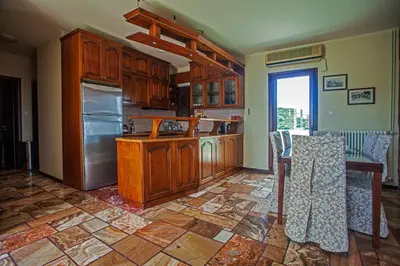 a kitchen with wooden cabinets and a stainless steel refrigerator at Villa Chloe - Amazing view Villa with swimming pool in Chania Town