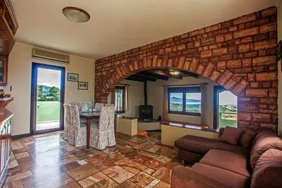 a living room with a brick wall and a table at Villa Chloe - Amazing view Villa with swimming pool in Chania Town