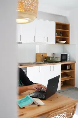 a person sitting at a table with a laptop at Lindas Convent Garden Home 1 in Chania Town