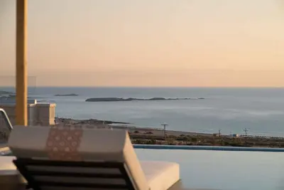 a chair sitting next to a swimming pool with the ocean at Actea Seaview Villas I 