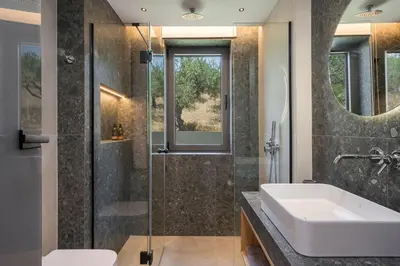 a bathroom with a sink and a shower at Villa Ekphrasis with sea view and jacuzzi in Ravdhoúkha