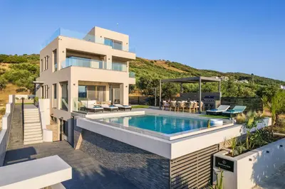 a villa with a swimming pool and a house at Villa Ekphrasis with sea view and jacuzzi in Ravdhoúkha