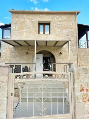 a house with a gate in front of a building at Kathiana cozy apartment in Kathiana