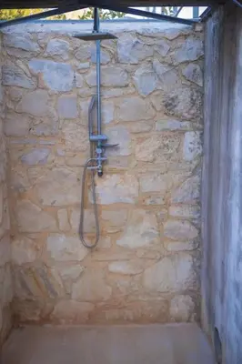 a stone bathroom with a shower in a stone wall at The Alcove Studio Chania in Chania Town