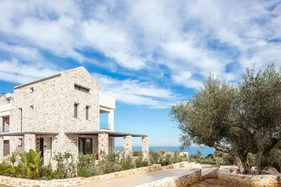 a stone house with a view of the ocean at Oinolithos Luxury Villas in Kalamaki Chanion