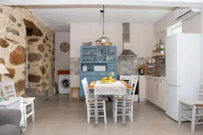 a kitchen and dining room with a table and chairs at DOLONAS Cosy House in Aliyoí