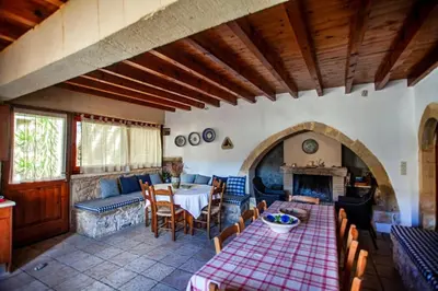a living room with a table and a fireplace at Villa Polirinia in Kissamos