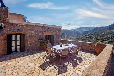 a table and chairs on a patio with a view at Villa Polirinia in Kissamos