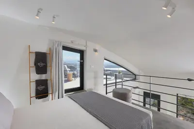 a bedroom with a bed and a large window at Pachnes Luxury Apartments - Heated Pool, Sea View in Kounoupidhianá