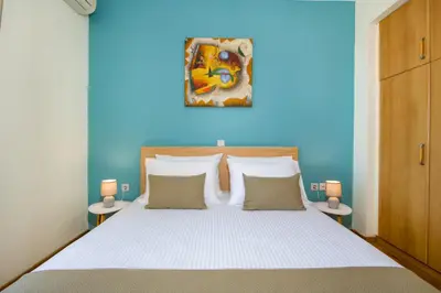a bedroom with a bed with a blue wall at Be Crete - vista Lazareta in Chania Town