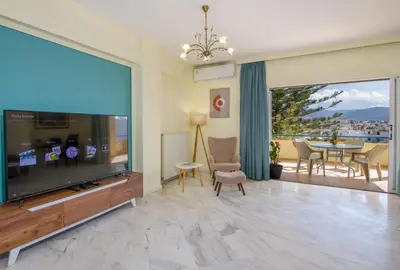 a living room with a large screen tv and a table at Be Crete - vista Lazareta in Chania Town