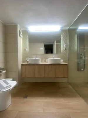 a bathroom with two sinks and a shower and a toilet at Be Crete - vista Lazareta in Chania Town