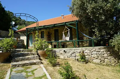 a house with a stone wall in front of it at Elpida Country House -Paleochora-Anidri in Palaiochóra
