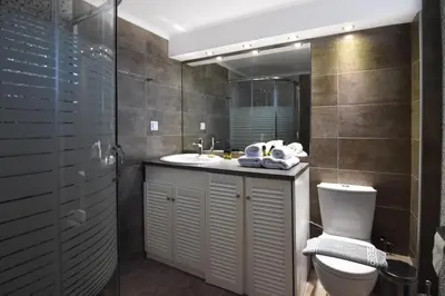 a bathroom with a sink and a toilet and a mirror at Hermes Hotel in Kissamos