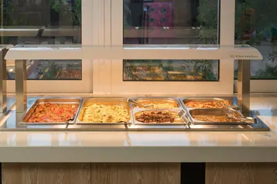a buffet with several trays of food on a counter at Hermes Hotel in Kissamos