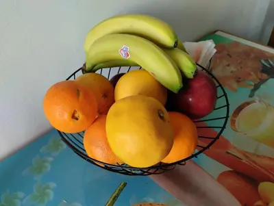 a bowl of fruit with bananas oranges and apples at EMMY APARTMENT in Chania Town