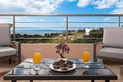 a table with cupcakes and orange juice on a balcony at The Cozy Nook in Chorafakia