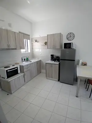 a kitchen with wooden cabinets and a refrigerator and a table at Sun Beach Apartment in Chania 15 in Chania Town