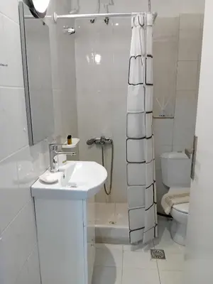 a white bathroom with a sink and a toilet at Sun Beach Apartment in Chania 15 in Chania Town