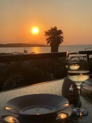 a table with a view of the ocean at sunset at Sun Beach Apartment in Chania 15 in Chania Town