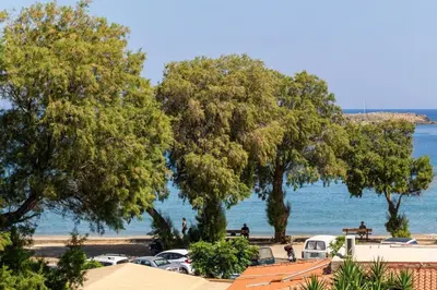 a view of a beach with trees and the water at Sun Beach Apartment in Chania 15 in Chania Town