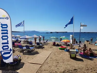 a group of people on a beach with flags at Sun Beach Apartment in Chania 15 in Chania Town