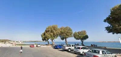 a parking lot with cars parked next to the water at Sun Beach Apartment in Chania 15 in Chania Town