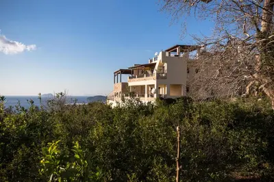 a building on top of a hill with bushes at Falasarna's Sunset Home in Falasarna