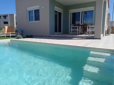 a swimming pool in front of a house at Nostalgico cottage in Chania Town