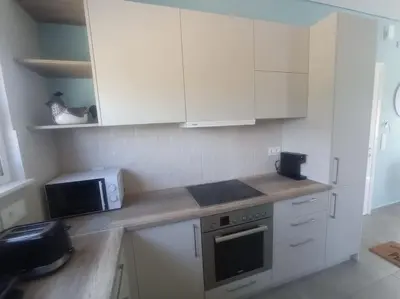 a kitchen with white cabinets and a microwave at Nostalgico cottage in Chania Town