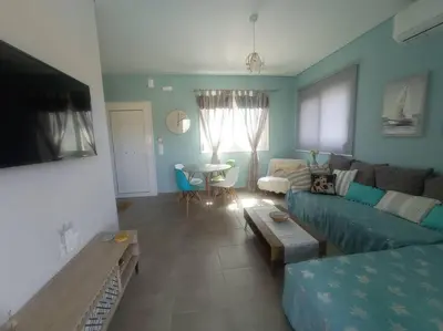 a living room with a blue couch and a table at Nostalgico cottage in Chania Town