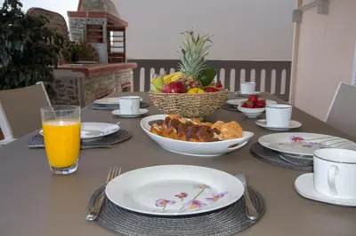 a table with plates of food and a bowl of fruit at Marakas Winery Family House in Xamoudhokhórion