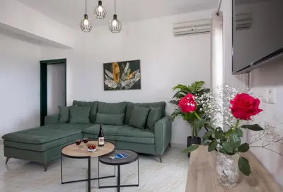 a living room with a green couch and red roses at Marakas Winery Family House in Xamoudhokhórion