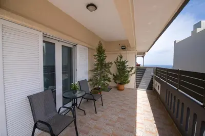 a patio with chairs and a table on a balcony at Marakas Winery Family House in Xamoudhokhórion