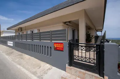 a house with a sign on a fence at Marakas Winery Family House in Xamoudhokhórion
