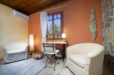 a living room with two chairs and a table and a window at Fortino Villa in Chorafakia