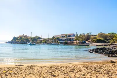 a view of a beach with houses in the background at Fortino Villa in Chorafakia