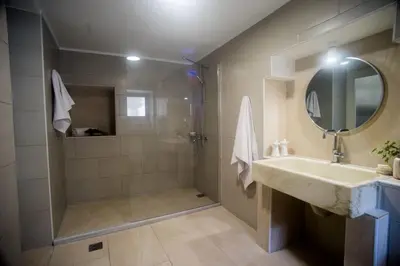 a bathroom with a shower and a sink and a mirror at Tatiana's Garden House in Chania Town