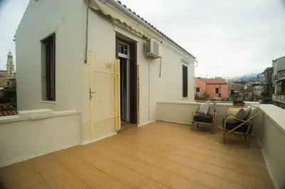 a balcony with two chairs and a door on a building at Tatiana's Garden House in Chania Town