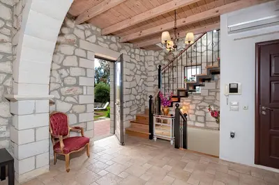 a hallway with a stone wall and a stairway at Villa Rea Chania in Argoulidhés