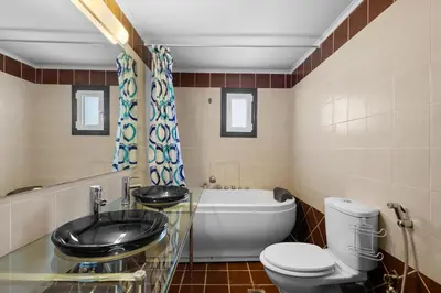 a bathroom with a tub and a toilet and a sink at Villa Rea Chania in Argoulidhés