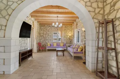 an archway in a living room with purple furniture at Villa Rea Chania in Argoulidhés