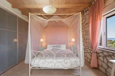 a bedroom with a white bed with a canopy at Villa Rea Chania in Argoulidhés