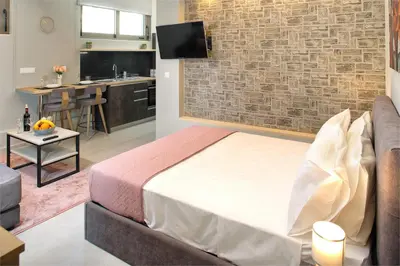 a bedroom with a bed and a brick wall at Mirma Halepa superior studio in Chania Town